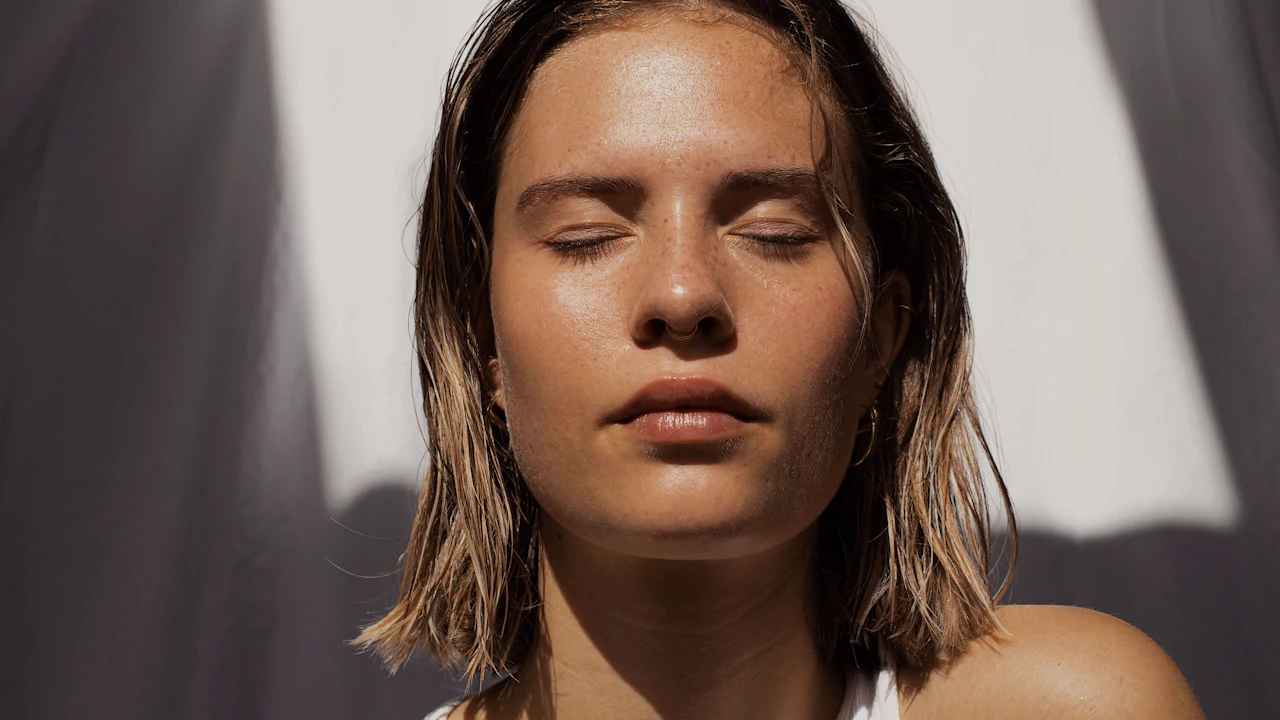 A calm face in warm natural light, showing healthy, natural skin