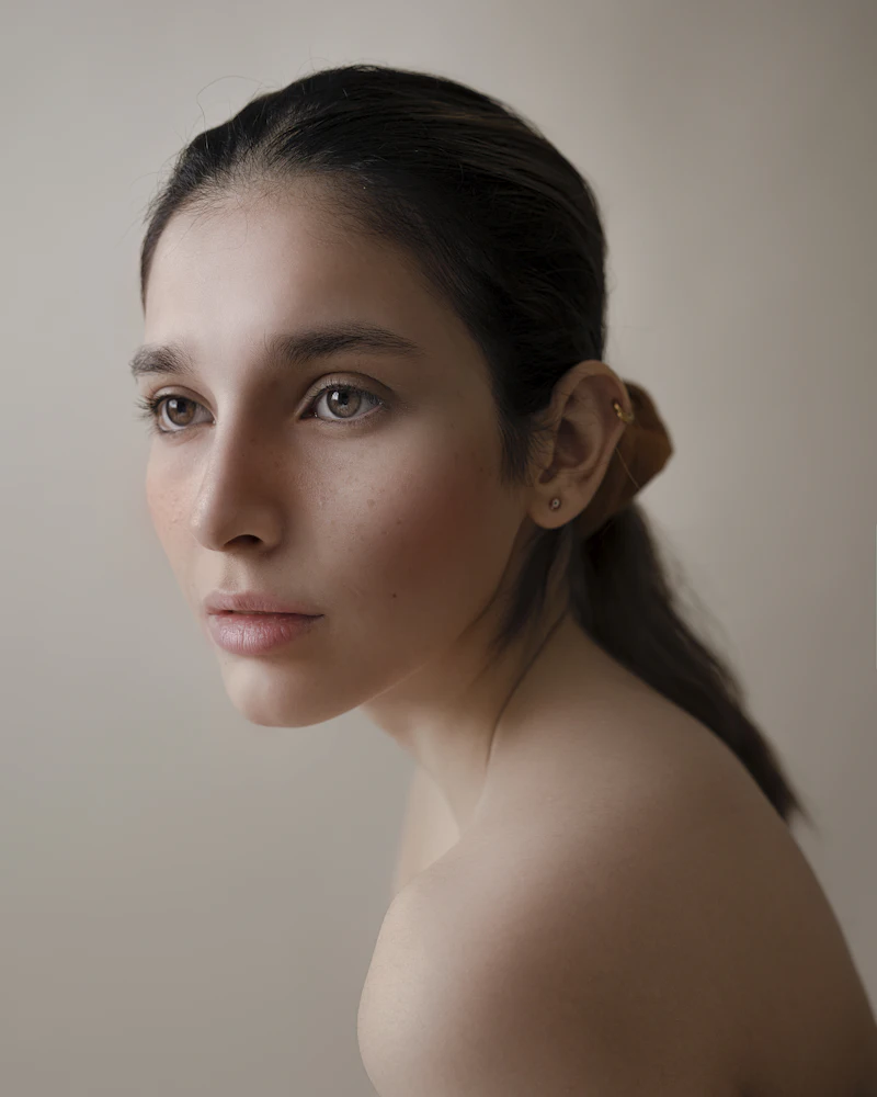 A composed studio portrait showing natural, real skin texture