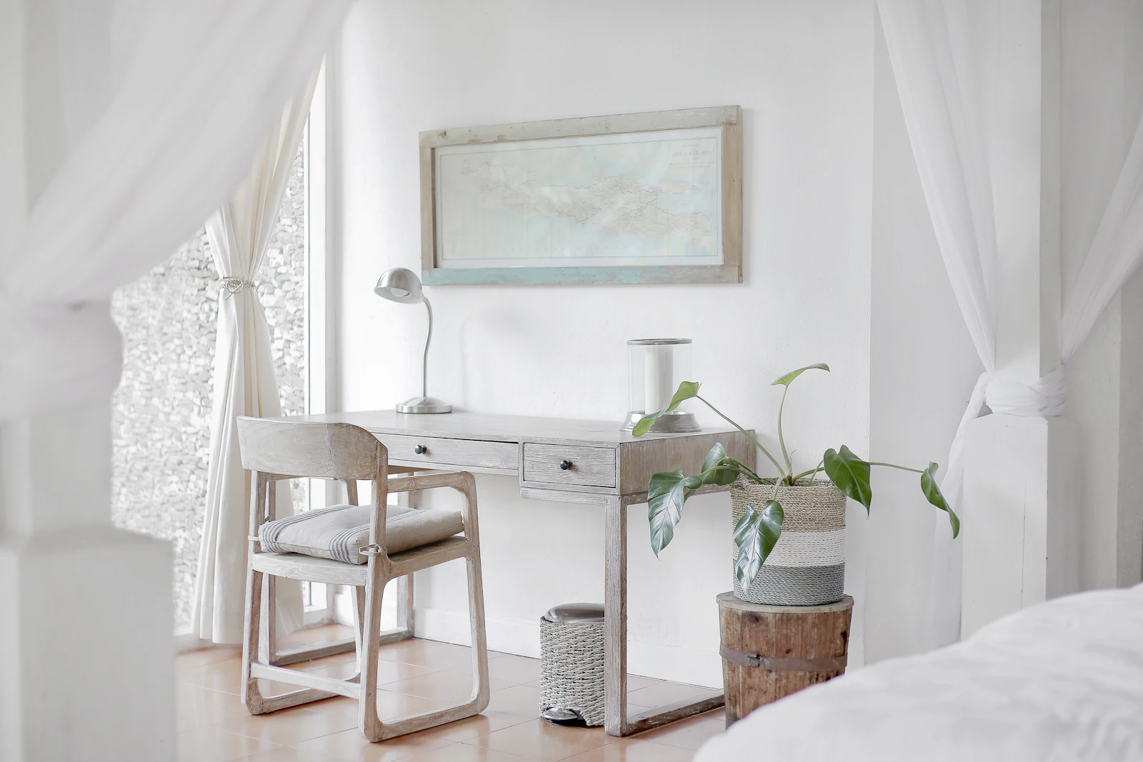 A calm, light-filled room with a simple wooden desk and chair