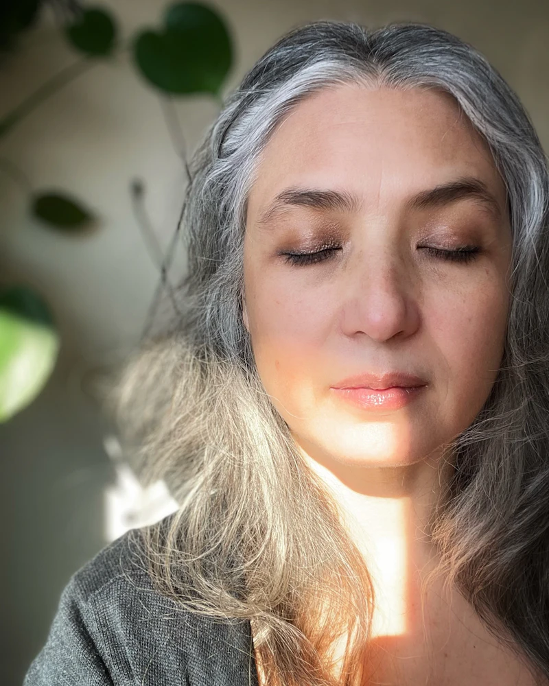 A woman with grey hair at ease in soft natural daylight